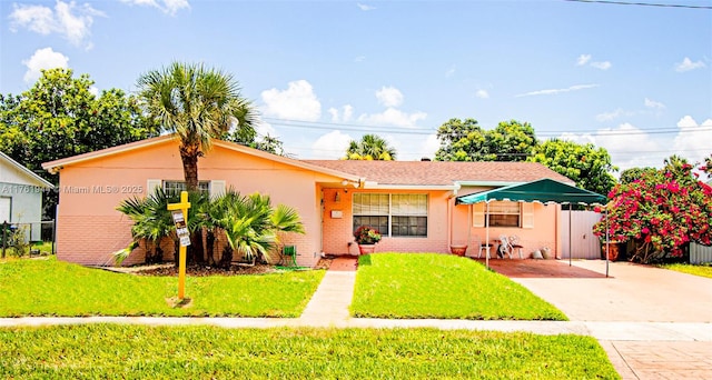 view of front of home featuring a front lawn, fence, and brick siding