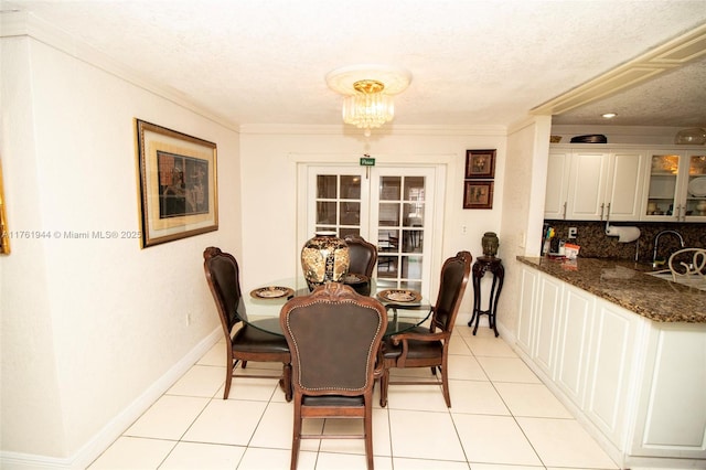 dining area with light tile patterned flooring, a textured ceiling, crown molding, and baseboards