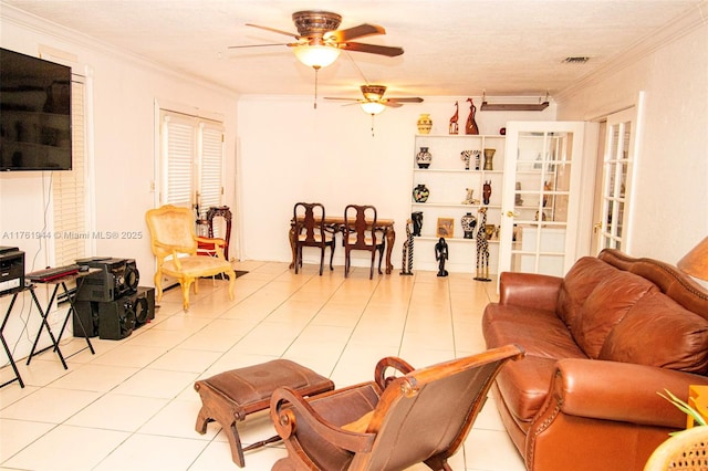 living area with tile patterned floors, a ceiling fan, and ornamental molding