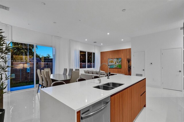 kitchen with modern cabinets, a sink, visible vents, dishwasher, and an island with sink