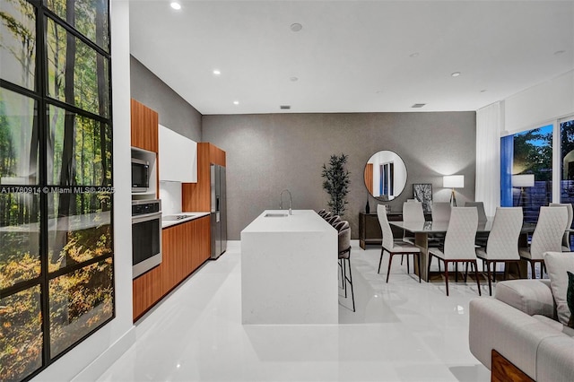 kitchen featuring recessed lighting, a sink, modern cabinets, stainless steel appliances, and open floor plan
