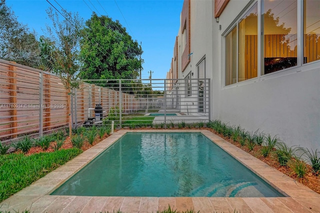 outdoor pool with a fenced backyard