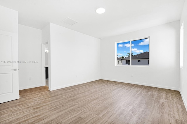 empty room with baseboards and wood finished floors