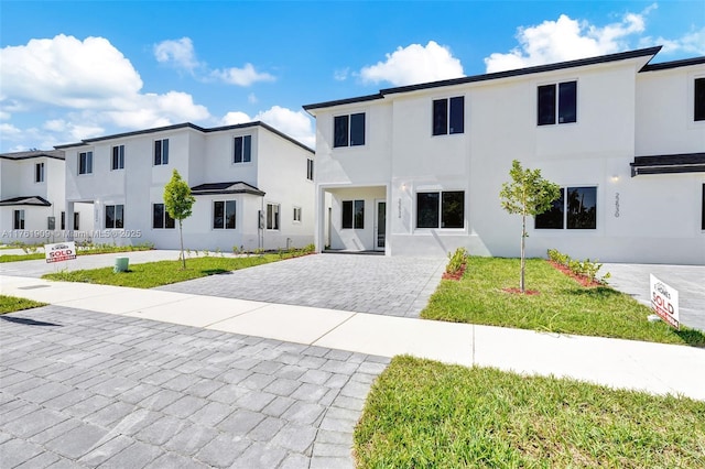 view of front facade featuring stucco siding and a front yard