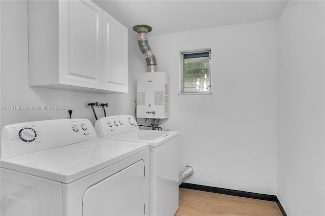 laundry room featuring light wood finished floors, baseboards, water heater, cabinet space, and independent washer and dryer