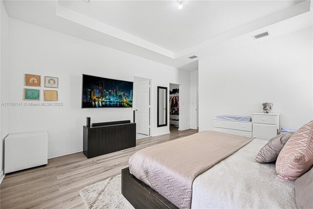 3489 W 110th Ter, Hialeah, FL 33018 - bedroom featuring visible vents, light wood-style floors, baseboards, and a tray ceiling