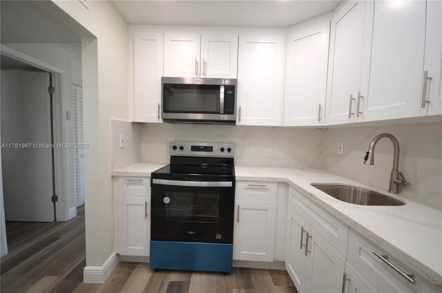 6070 W 18th Ave Unit 310, Hialeah, FL 33012 - kitchen featuring stainless steel microwave, electric range, a sink, and wood finished floors