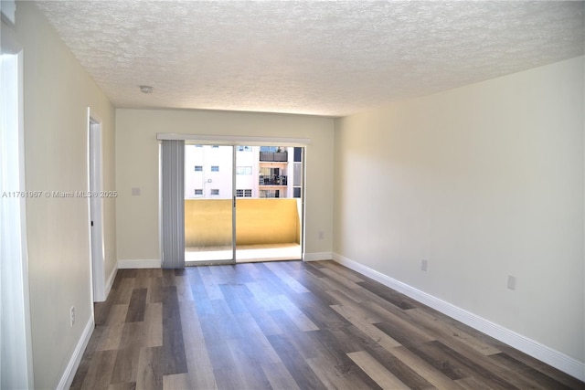 spare room with dark wood finished floors, baseboards, and a textured ceiling