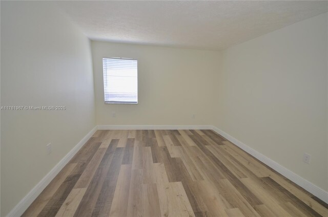 6070 W 18th Ave Unit 310, Hialeah, FL 33012 - empty room featuring light wood finished floors and baseboards