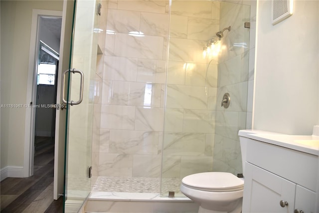 bathroom with vanity, wood finished floors, visible vents, a stall shower, and toilet