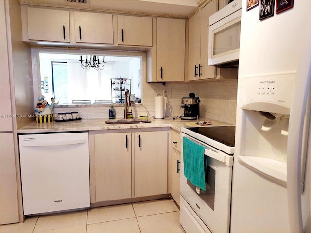 kitchen featuring tasteful backsplash, light countertops, light tile patterned flooring, white appliances, and a sink