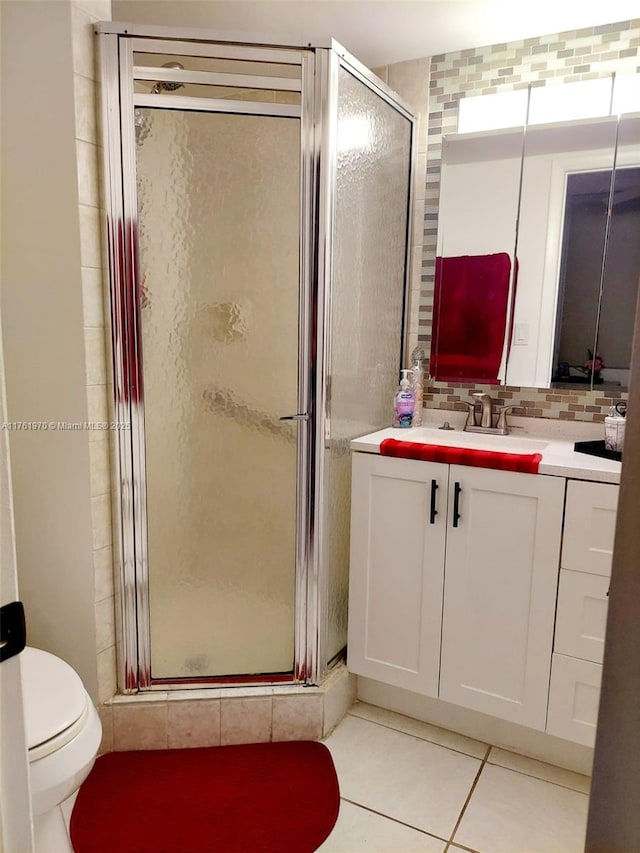 full bath with vanity, a stall shower, tile patterned flooring, toilet, and tasteful backsplash