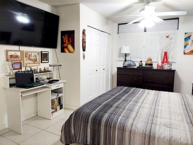 bedroom with ceiling fan, a closet, and light tile patterned flooring