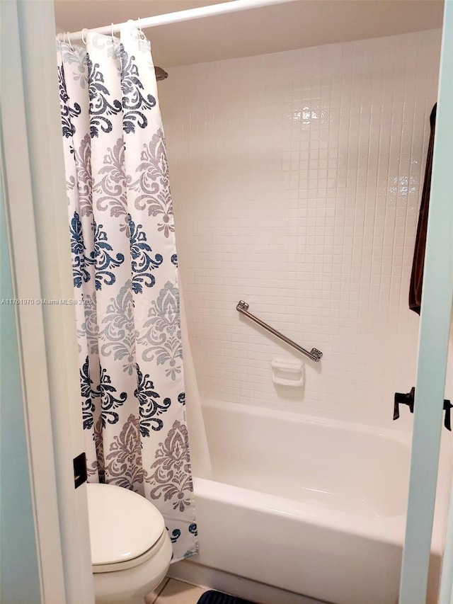 bathroom with toilet and shower / tub combo with curtain