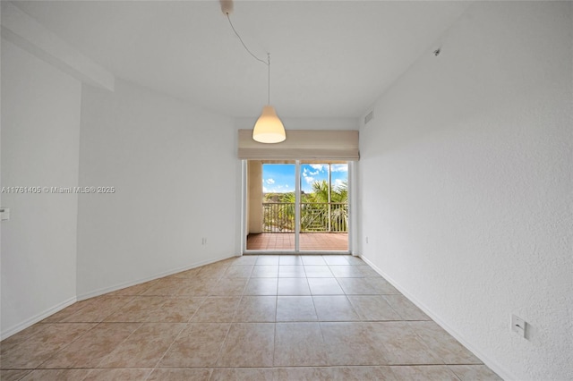 spare room featuring tile patterned floors, visible vents, and baseboards