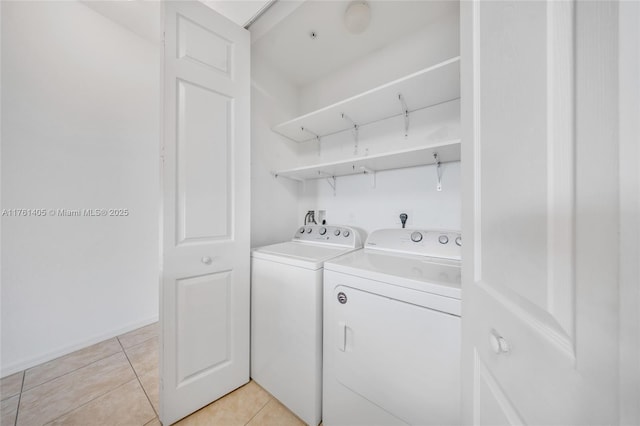 laundry area with light tile patterned floors, washer and dryer, and laundry area