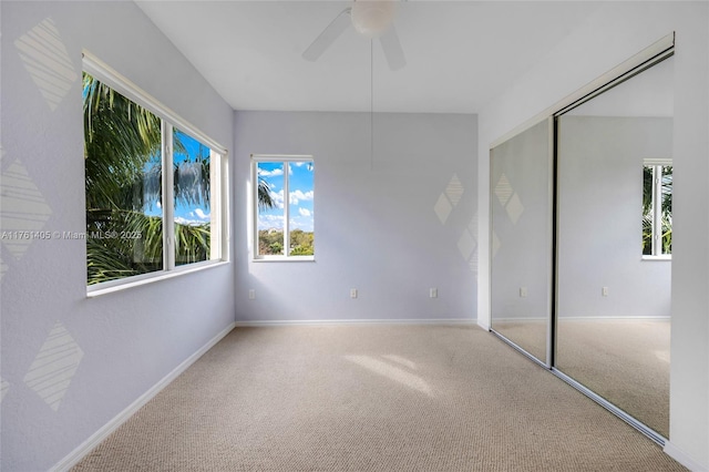 unfurnished bedroom featuring baseboards, ceiling fan, carpet floors, and a closet