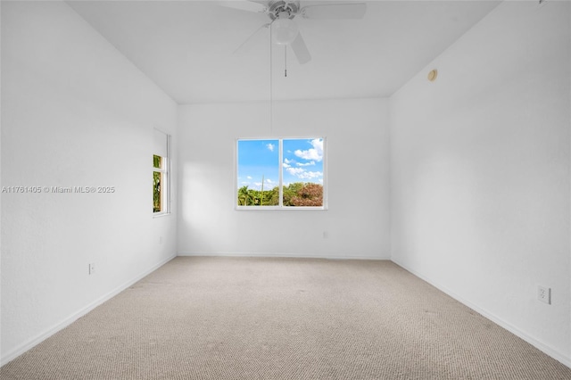 carpeted empty room featuring ceiling fan and baseboards