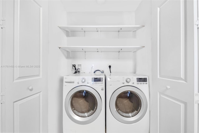 clothes washing area with washing machine and clothes dryer and laundry area