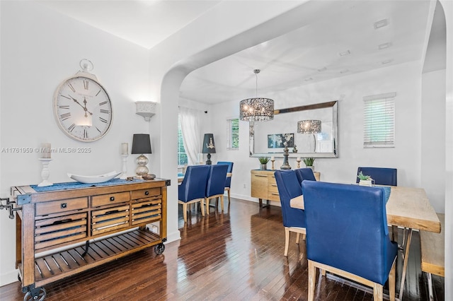 dining room with arched walkways, a notable chandelier, baseboards, and hardwood / wood-style flooring