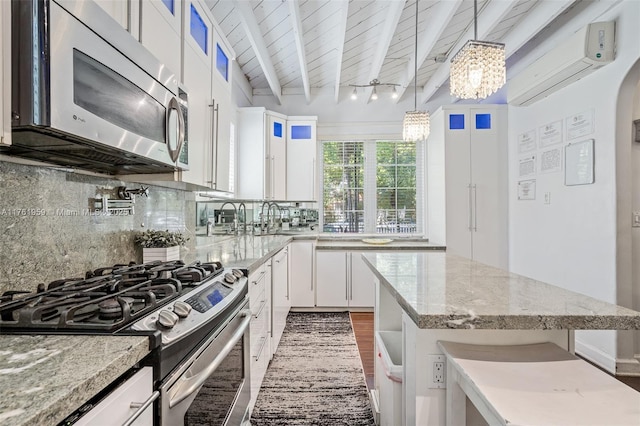 kitchen with beamed ceiling, decorative light fixtures, backsplash, white cabinetry, and appliances with stainless steel finishes