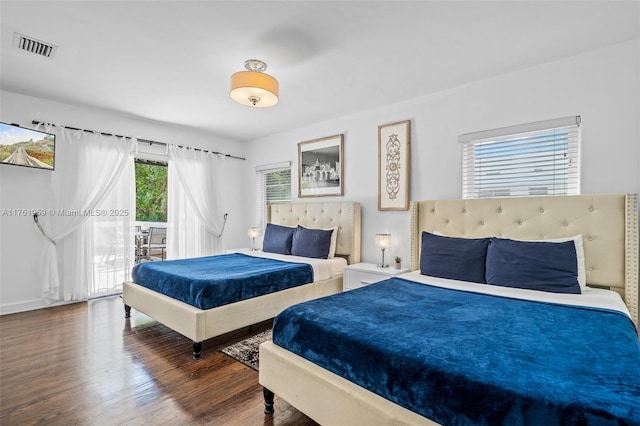 bedroom with access to exterior, visible vents, and wood finished floors