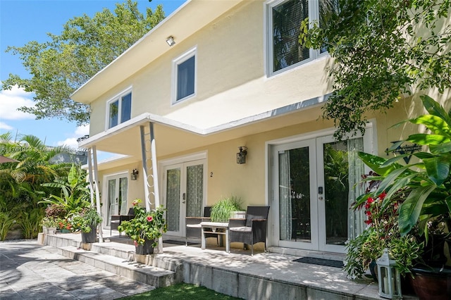 back of property with french doors, a patio, and stucco siding