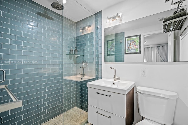 full bathroom featuring toilet, vanity, tiled shower, and speckled floor