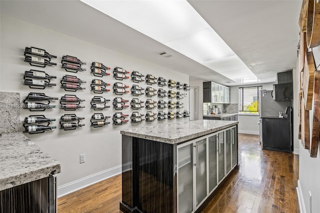 kitchen with dark wood-style floors, visible vents, backsplash, and baseboards