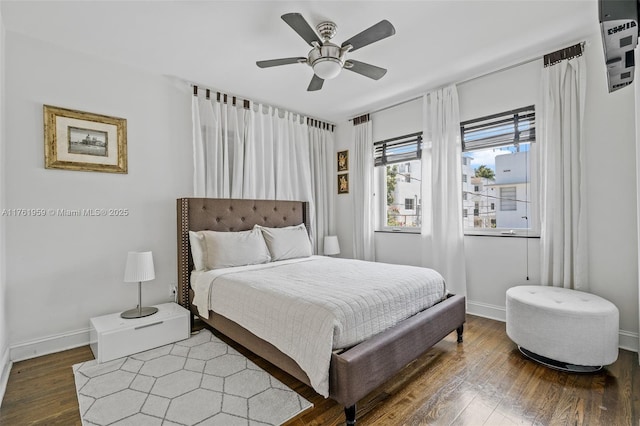 bedroom with baseboards, wood finished floors, and a ceiling fan