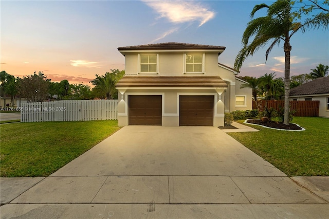 view of front facade with a front lawn, fence, concrete driveway, stucco siding, and a garage