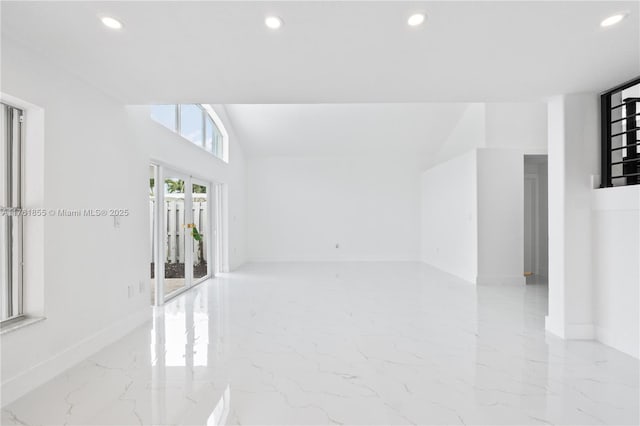 empty room with recessed lighting, baseboards, and marble finish floor