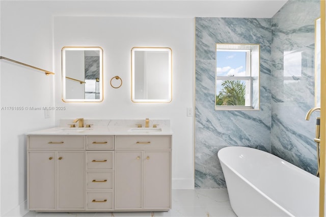 bathroom with double vanity, a freestanding bath, marble finish floor, and a sink