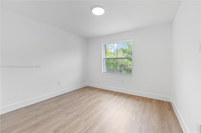 spare room featuring light wood-style floors and baseboards