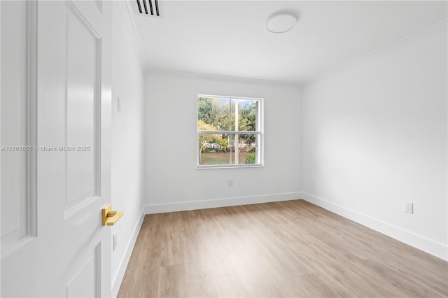 empty room with visible vents, baseboards, crown molding, and light wood finished floors