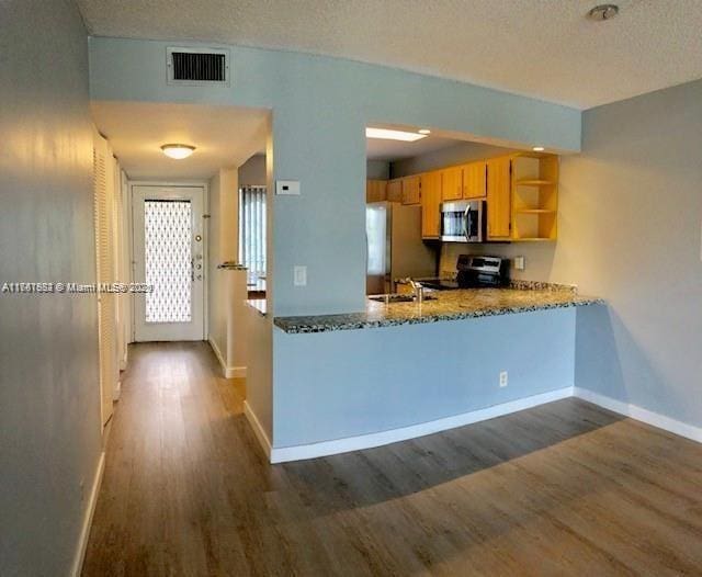 kitchen featuring dark wood-type flooring, visible vents, open shelves, and stainless steel appliances