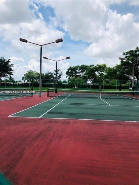 view of tennis court featuring fence