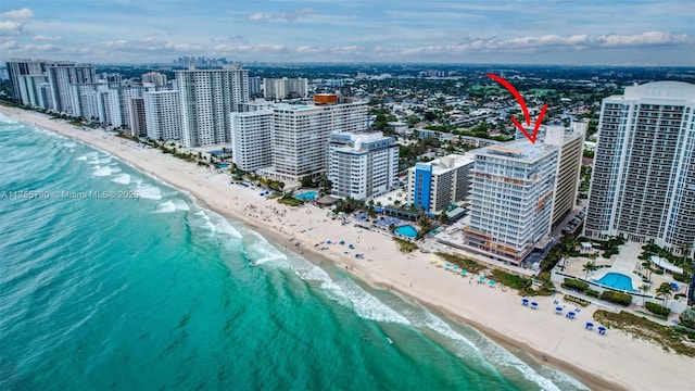 drone / aerial view with a city view, a beach view, and a water view