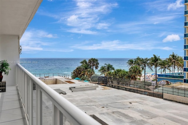 balcony featuring a beach view and a water view