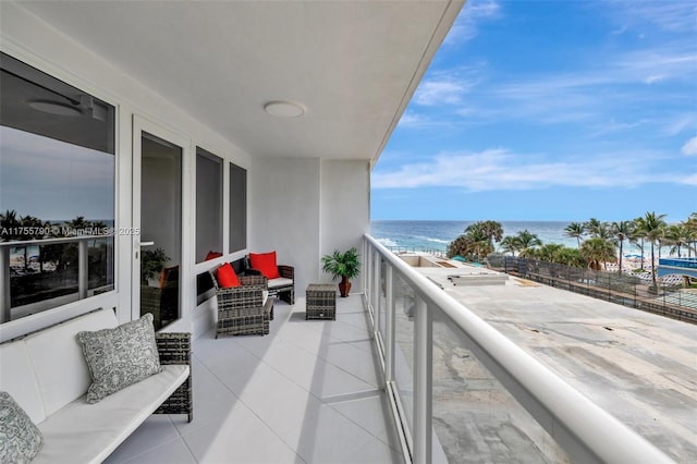 balcony featuring an outdoor hangout area, a view of the beach, and a water view