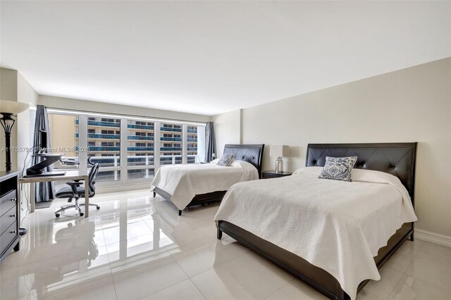 bedroom with light tile patterned floors and baseboards