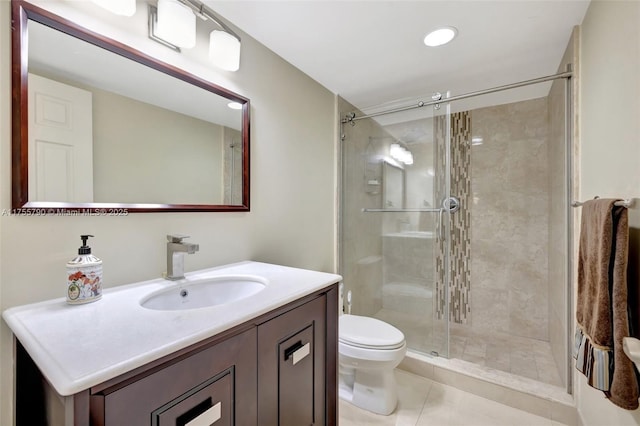 bathroom featuring tile patterned floors, vanity, a shower stall, and toilet