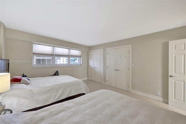 bedroom featuring two closets and baseboards