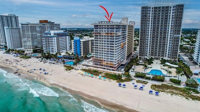 drone / aerial view with a view of city, a view of the beach, and a water view