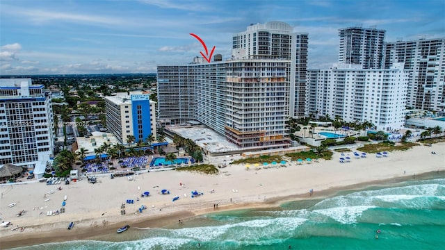 drone / aerial view featuring a view of city, a beach view, and a water view