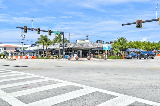 view of street with traffic signs, sidewalks, street lighting, and traffic lights