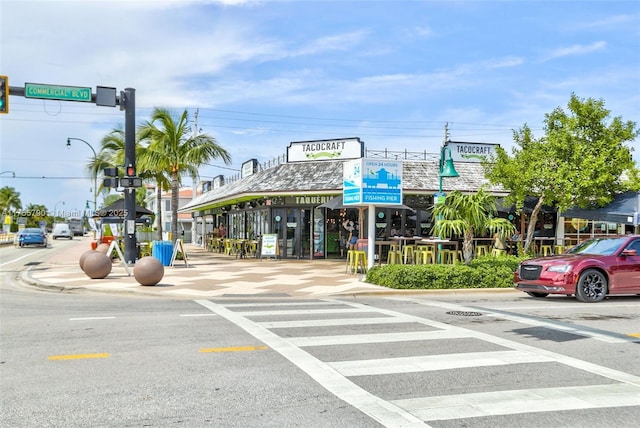 view of road featuring curbs, street lights, traffic lights, and sidewalks