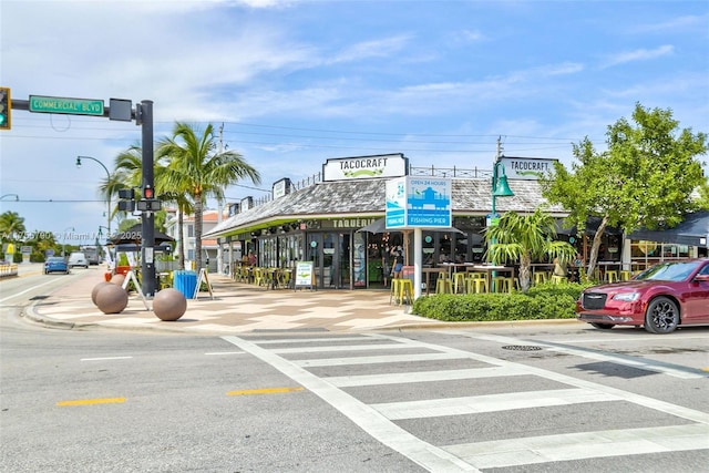 view of street with curbs, sidewalks, street lighting, and traffic lights