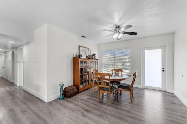 dining room with visible vents, ceiling fan, baseboards, and wood finished floors