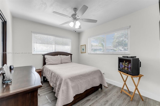 bedroom featuring light wood finished floors, ceiling fan, and baseboards